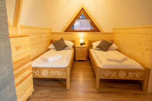 two twin beds in a room with a window at Domki na Wierchu - z widokiem na góry in Białka Tatrzanska