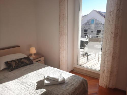 une chambre avec un lit et une grande fenêtre dans l'établissement Apartments Villa Beba, à Komiža