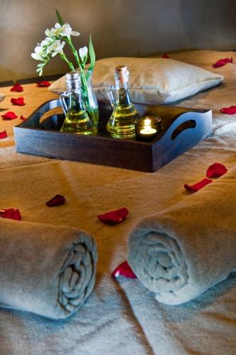 a table with two bottles and a candle and flowers at Marigold Thermal & Spa Hotel Bursa in Bursa
