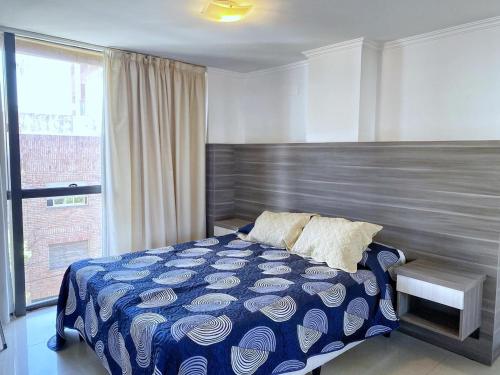 1 dormitorio con cama y ventana grande en SAN NICOLAS en Villa Carlos Paz