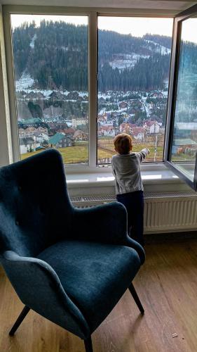 a person looking out of a large window with a chair at Premium Club SPA in Bukovel