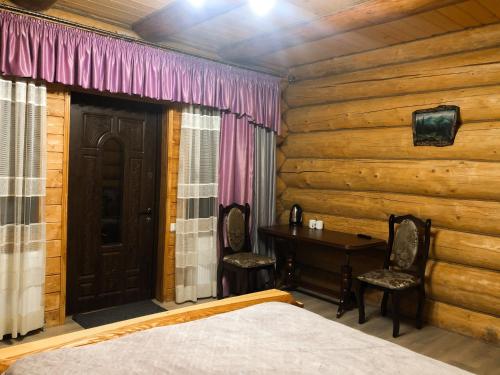 a bedroom with a bed and a table and a door at Зимова казка in Tatariv
