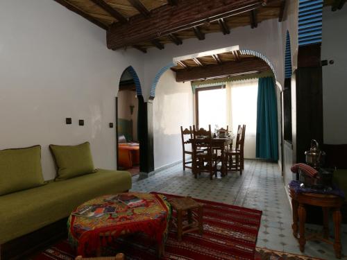 a living room with a couch and a table at Kasbah Du Roches Armed in Imlil