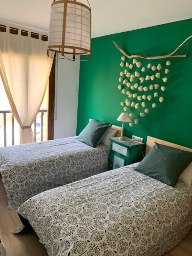 2 camas en un dormitorio con paredes verdes en Apartament La Ruella, en Sort