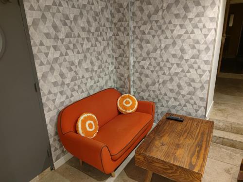 オンフルールにあるLe Saint Léonard...Il est Jauneのオレンジの椅子(テーブル上にオレンジの枕2つ付)