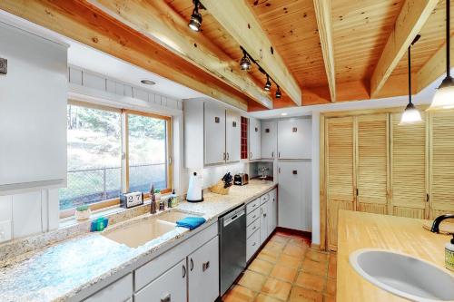 una cocina con 2 lavabos y una ventana grande en Northwoods Dream Retreat, en Whitefish