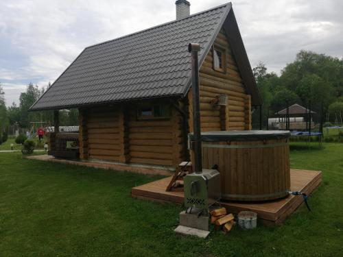 a log cabin with a hot tub in the yard at Rähni Guesthouse Lake Peipsi in Vilusi
