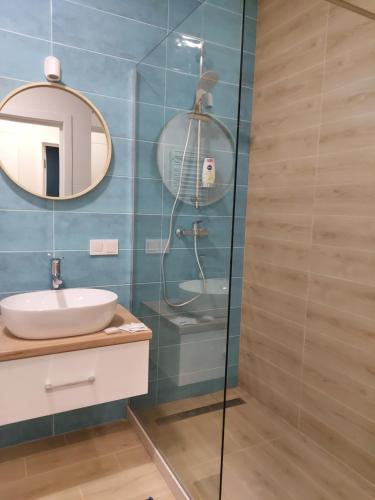 La salle de bains est pourvue d'un lavabo et d'une douche. dans l'établissement Prestige Apartments, à Rivne