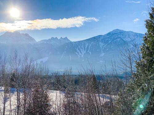 a snow covered mountain range with the sun in the sky at Coast Hillcrest Hotel in Revelstoke
