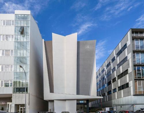 a large white building next to two tall buildings at Hotel BESTPRICE Alcalá in Madrid