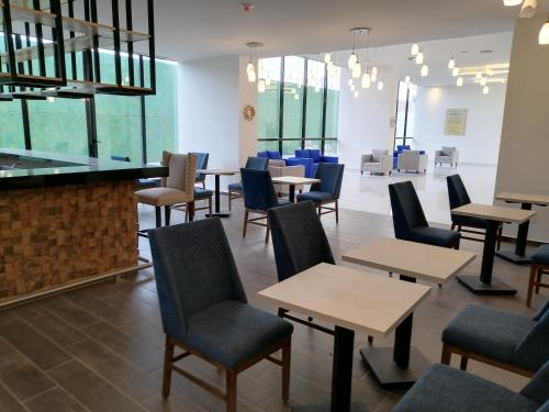 a dining room with tables and chairs and a bar at Wyndham Puebla Angelopolis in Puebla