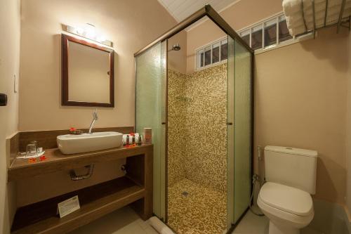 a bathroom with a shower and a toilet and a sink at Pousada Araras Pantanal Eco Lodge in Carvoalzinho