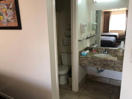 a bathroom with a sink and a toilet and a mirror at Ameri-Stay Inn & Suites in Clearfield