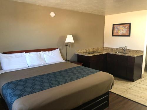 a hotel room with a bed and a sink at Ameri-Stay Inn & Suites in Clearfield
