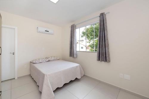 Habitación pequeña con cama y ventana en Aluguel Apartamento 2 quartos s/ 1 suíte Bombas/SC, en Bombinhas