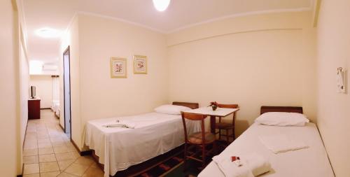 テイシェイラ・デ・フレイタスにあるLord Plaza Hotelのベッド2台とテーブルがある部屋