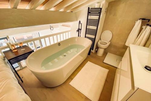 La salle de bains est pourvue d'une grande baignoire et de toilettes. dans l'établissement Luxe Penthouse Les Pieds dans l’eau Saint-Tropez 4, à Cogolin