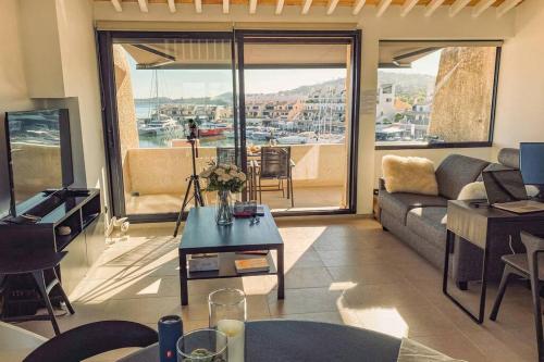 un salon avec un canapé et une grande fenêtre dans l'établissement Luxe Penthouse Les Pieds dans l’eau Saint-Tropez 4, à Cogolin