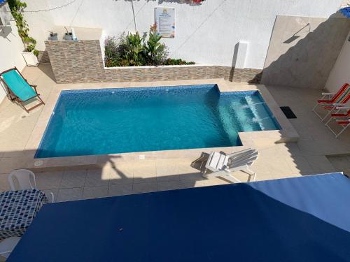 a swimming pool with two chairs and a table at Mar de Indias House in Cartagena de Indias