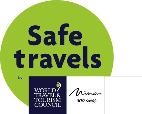 Una señal que dice "viajes seguros" y una señal que dice Consejo Mundial de Turismo en Hotel Dom Henrique, en Timóteo