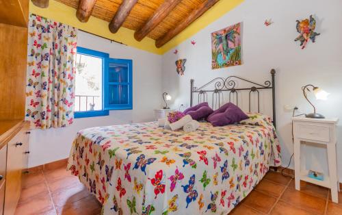 a bedroom with a bed and a window at La Casita de las Mariposas in Frigiliana