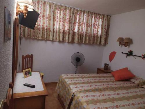 sypialnia z łóżkiem, stołem i biurkiem w obiekcie Apartamento Neptuno playa 06 w mieście Puerto de Santiago