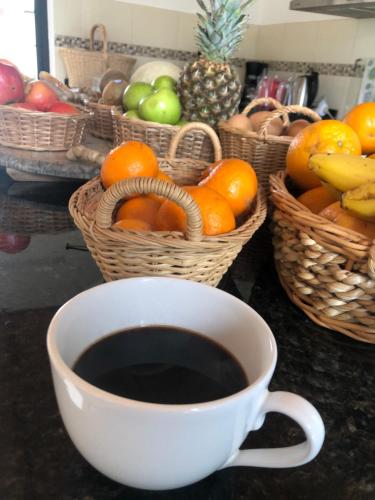 una taza de café junto a cestas de fruta en La Posadita, en José Ignacio