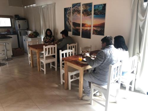 a group of people sitting around a wooden table at La Posadita in José Ignacio