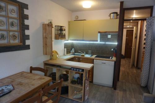 uma pequena cozinha com mesa e bancada em le bel aval em Les Contamines-Montjoie