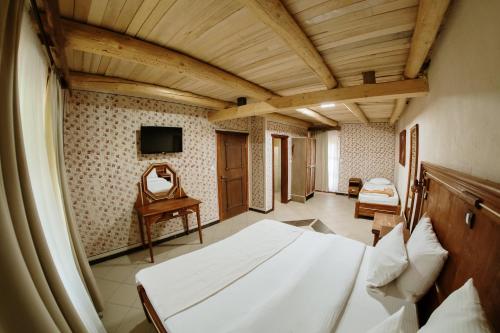 a bedroom with a bed and a tv on a wall at Etno hotel Balasevic Rtanj in Boljevac