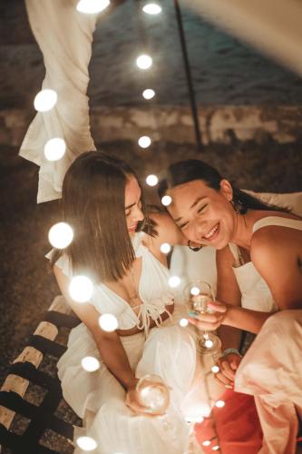 two women and a man sitting at a table with lights at Marbelo Coveñas by Bernalo Hotels in Coveñas