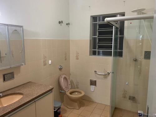 a bathroom with a toilet and a sink and a shower at Casa Familiar Proença 15 solteiros ou 21 se 2 nas camas de casais in Campinas