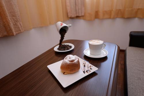 uma mesa com uma chávena de café e um bolo sobre ela em Hotel Belvedere em Vatra Dornei
