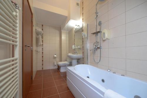 ヴァトラ・ドルネイにあるHotel Belvedereのバスルーム(バスタブ、トイレ、シンク付)