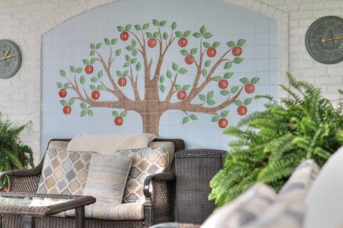 a tree mural on the wall of a room with a couch at The Inn at Apple Valley, an Ascend Collection Hotel in Pigeon Forge
