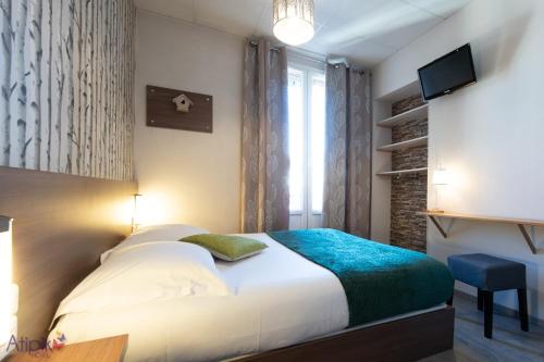 a bedroom with a bed and a tv and a window at Atipik Hôtel in Annecy