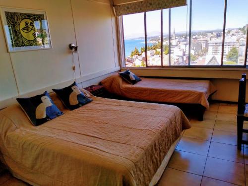 um quarto de hotel com duas camas e uma grande janela em Apartamento Bariloche Center em San Carlos de Bariloche