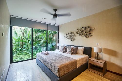 sypialnia z łóżkiem i wentylatorem sufitowym w obiekcie Modern Jungle Hideaway with Private Pool in Aldea Zama w mieście Tulum