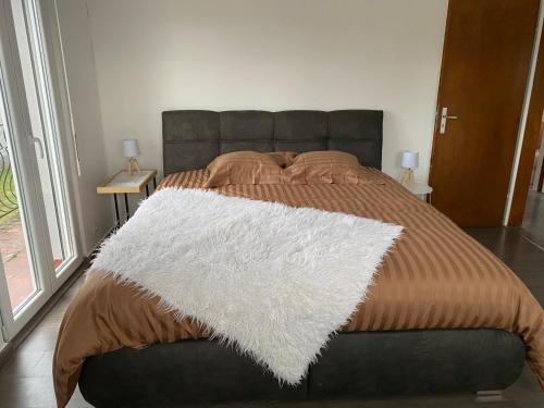 a bedroom with a bed with a white blanket on it at Gîte Célia in Sélestat