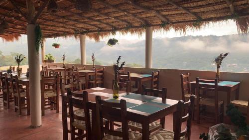 a restaurant with tables and chairs with a view at Hotel CaféNaranja Xilitla in Xilitla