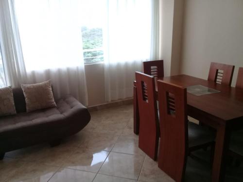 a living room with a couch and a table and chair at Departamento playa Tonsupa, Esmeraldas in Tonsupa