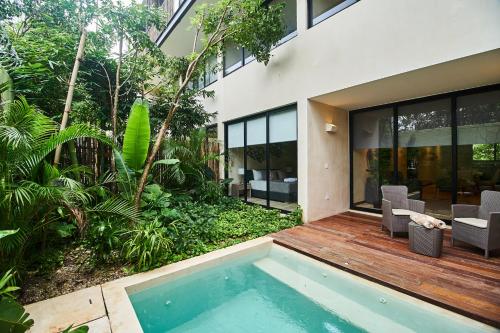 a house with a swimming pool in front of a house at Aldea Zama Hideaway with Private Pool in Gated Community in Tulum