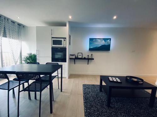 ein Wohnzimmer mit einem Tisch und Stühlen sowie eine Küche in der Unterkunft Appartement les Falaises in Cap d'Agde