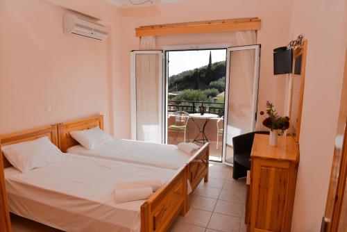 1 dormitorio con 1 cama grande y balcón en Paradise Apartments en Paleokastritsa