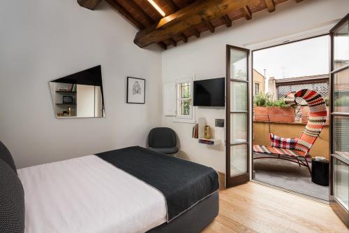 フィレンツェにあるホテル ミルーのベッドルーム1室(ベッド1台付)、スライド式ガラスドアが備わります。