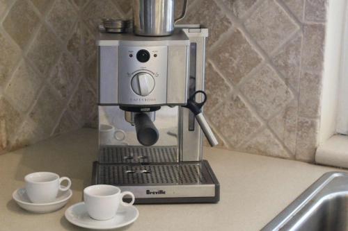 a coffee machine sitting on a counter with two cups at Banana Tree Casa in Eden