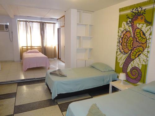 a room with two beds and a wall with a dragon on it at OUR Place 2 in San Andrés