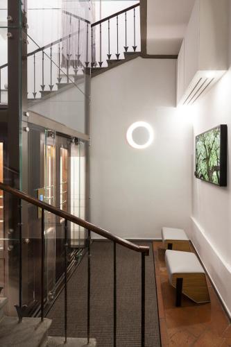 a hallway with a staircase with a bench and a picture at Hotel Milu Florence in Florence
