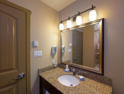 a bathroom with a sink and a large mirror at Bayview Hotel in Courtenay