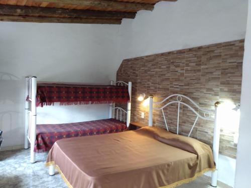 a bedroom with a bed and a brick wall at Amanecer en Cuyo in San Rafael